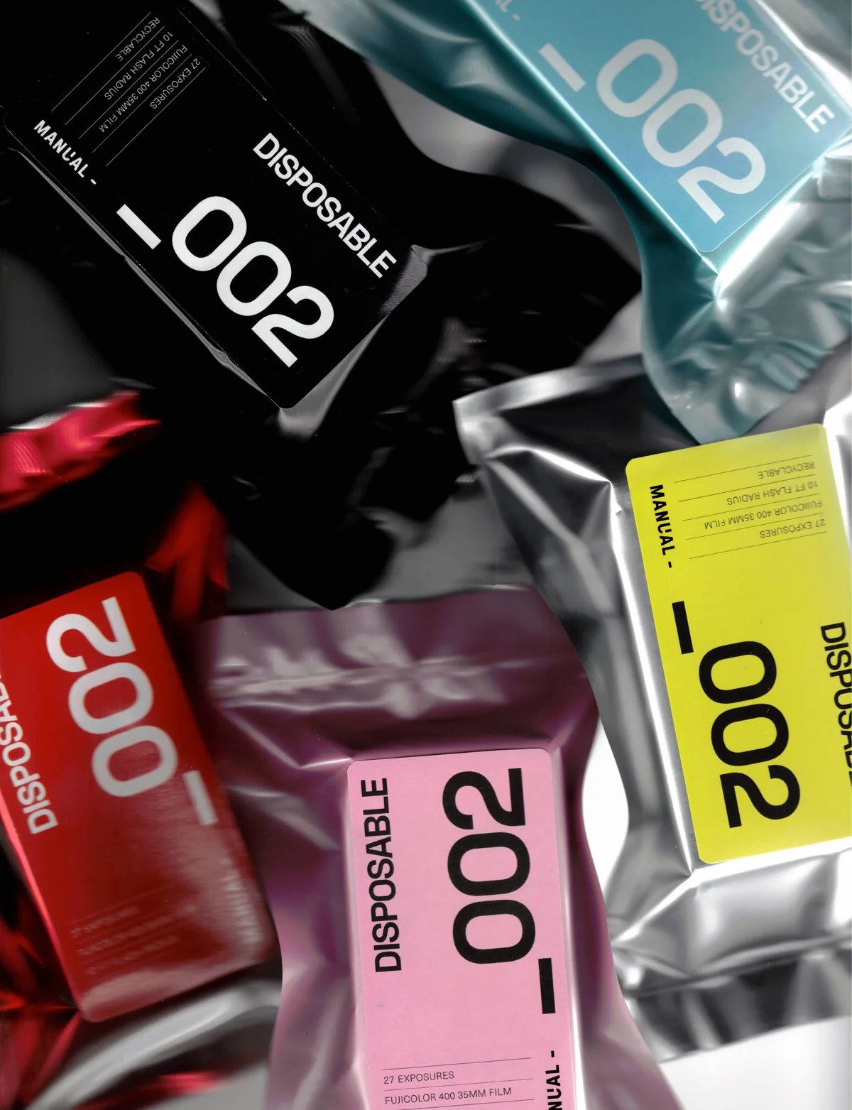 Manual _002 disposable cameras in black, blue, red, pink and yellow foil packs